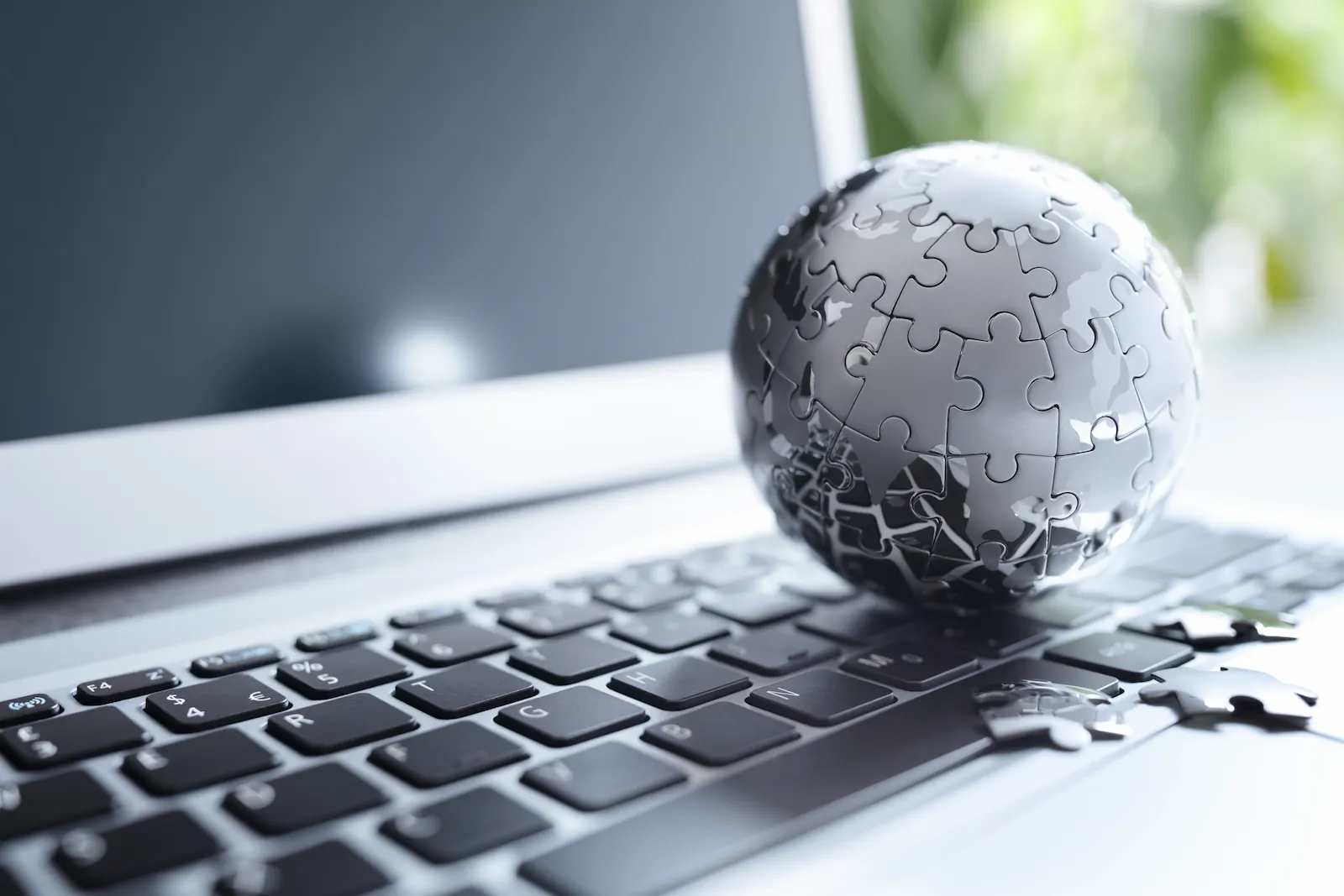 Laptop mit Puzzle-Globus — digitale Reichweite
